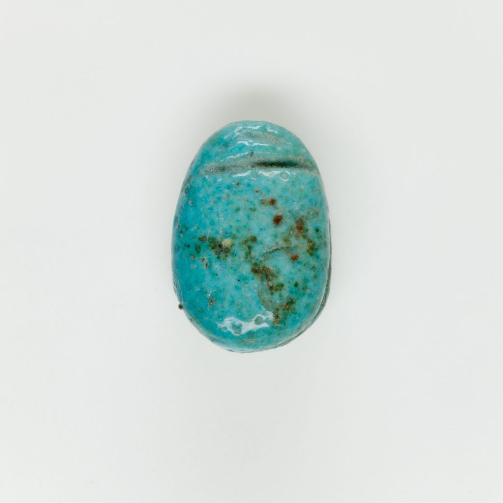 Small ancient Egyptian blue faience scarab bead without inscription, found in a funerary context.